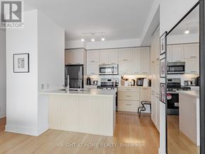 Toronto (Willowdale East) condo for rent - A modern kitchen with white cabinets and appliances.