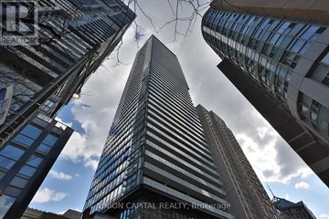 Toronto (Bay Street Corridor) condo for rent - A tall building stands in the middle of a cityscape.