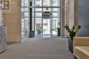 Toronto (Bay Street Corridor) condo for rent - A lobby with a plant, a couch, and a glass door.