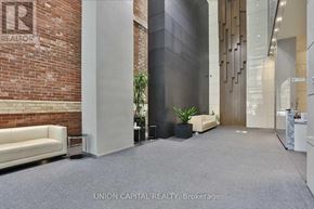 Toronto (Bay Street Corridor) condo for rent - A lobby area with a brick wall and a white sofa.