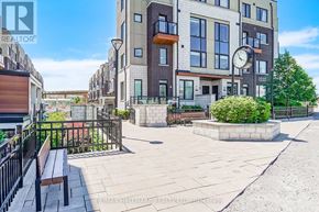 Pickering (Town Centre) townhouse for rent - A modern apartment complex with a clock on the front of the building.