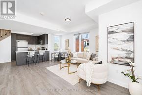 Pickering (Town Centre) townhouse for rent - A modern living room with a white sofa and a painting on the wall.