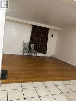 Brampton (Madoc) apartment for rent - A room with a wooden floor and a chair with a table.
