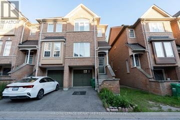 Mississauga (Hurontario) townhouse for rent - A white car is parked in front of a brick building.