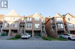 Mississauga (Hurontario) townhouse for rent - A white car is parked in front of a brown building.