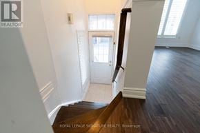 Mississauga (Hurontario) townhouse for rent - A hallway with a wooden floor leading to a white door.