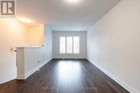 Mississauga (Hurontario) townhouse for rent - A spacious room with wooden floors and white walls.