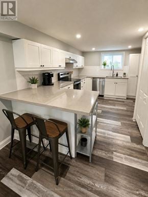 Welland (N. Welland) apartment for rent - A kitchen with white cabinets and a bar area with two stools.