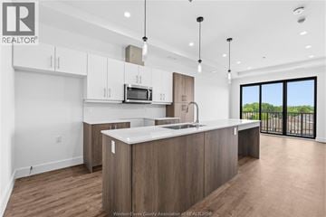 Windsor condo for rent - A modern kitchen with wooden cabinets and a large island.