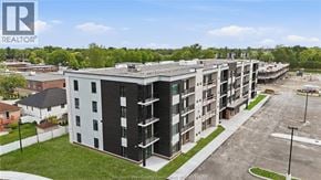 Windsor condo for rent - A large apartment complex with multiple buildings and a parking lot in front.