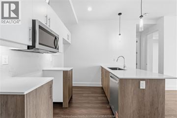 Windsor condo for rent - A modern kitchen with wooden cabinets and a white countertop.