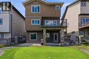 Calgary apartment for rent - A two-story house with a balcony and a bicycle parked in front.