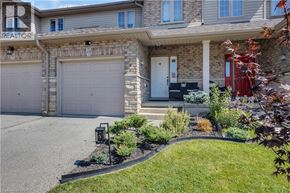 Brantford townhouse for rent - A house with a grey garage door and a red door.