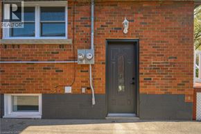 Hamilton apartment for rent - A red brick house with a grey door and a window.