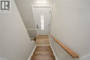 Hamilton apartment for rent - A white door with a window in the middle is at the end of a wooden staircase.