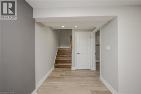 Hamilton apartment for rent - A hallway with a white door and wooden stairs.