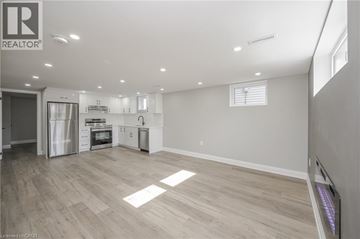 Hamilton apartment for rent - A spacious kitchen with white cabinets and a refrigerator.
