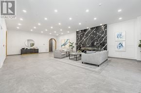Guelph (St. Patrick's Ward) condo for rent - A spacious living room with a grey sofa and a marble wall.