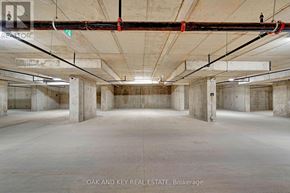 London East (East K) condo for rent - A large, empty warehouse with concrete floors and exposed ceiling beams.