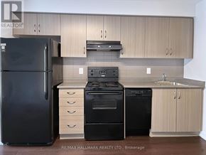 Toronto (Moss Park) condo for rent - A kitchen with a black fridge, black oven and black dishwasher.