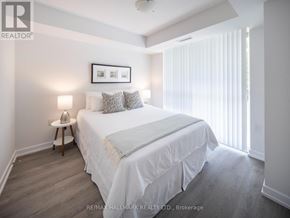 Toronto (Moss Park) condo for rent - A bedroom with a bed, nightstand, and a picture frame on the wall.