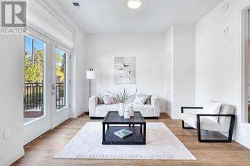 London East (East K) condo for rent - A well-lit, modern living room with a white sofa set, a coffee table, and a large window.
