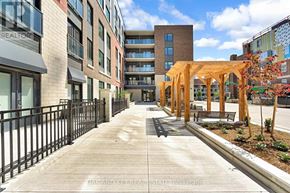 London East (East K) condo for rent - A walkway with a fence on one side and a row of buildings on the other.