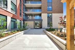 London East (East K) condo for rent - A modern building with a glass entrance and a wooden post on the right side.