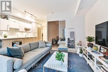 Toronto (Waterfront Communities) condo for rent - A living room with a grey sofa and a television on the right side.