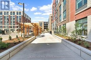 London East (East K) condo for rent - A street view of a residential area with apartment buildings and a wooden structure in the middle.