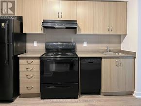 Toronto (Moss Park) condo for rent - A kitchen with black appliances and wooden cabinets.