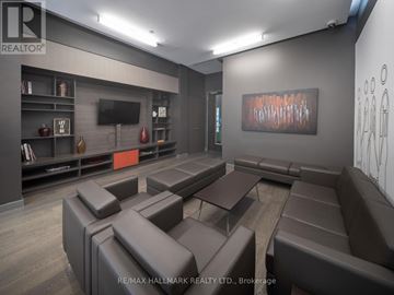 Toronto (Moss Park) condo for rent - A modern living room with brown leather furniture and a painting on the wall.