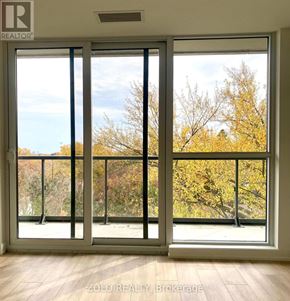 Toronto (Willowdale East) condo for rent - A room with a view of trees through a large window.