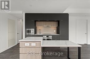 Toronto (Oakwood Village) condo for rent - A modern kitchen with a marble countertop and dark cabinets.