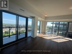 Clarington (Bowmanville) condo for rent - A spacious room with a view of the cityscape through large windows.