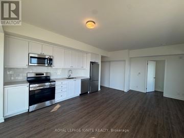 Clarington (Bowmanville) condo for rent - A kitchen with white cabinets and a stainless steel oven.