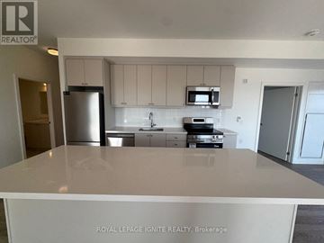 Clarington (Bowmanville) condo for rent - A kitchen with white cabinets and appliances is for sale.