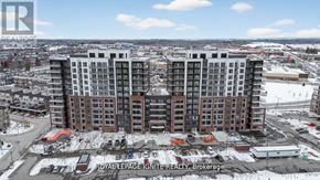 Clarington (Bowmanville) condo for rent - A large, multi-story building with a parking lot in front of it.