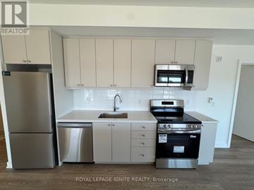 Clarington (Bowmanville) condo for rent - A kitchen with white cabinets and stainless steel appliances.