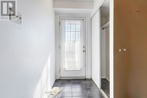 Ottawa townhouse for rent - A hallway with a white door and a window with curtains.