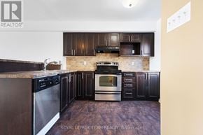 Ottawa townhouse for rent - A kitchen with dark wood cabinets and stainless steel appliances.