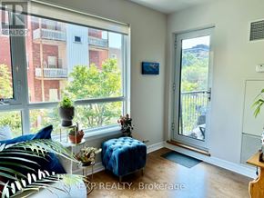 Ottawa condo for rent - A living room with a blue couch and a large window.