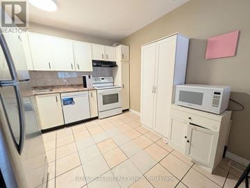 Ottawa townhouse for rent - A kitchen with white cabinets and appliances.