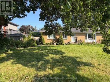 Ottawa apartment for rent - A sunny day in a residential area with houses and green lawns.