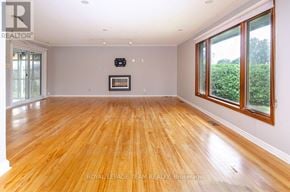 Ottawa apartment for rent - A spacious room with wooden flooring and a large window on the right side.