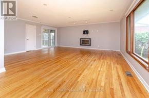 Ottawa apartment for rent - A spacious room with wooden flooring and sliding glass doors.