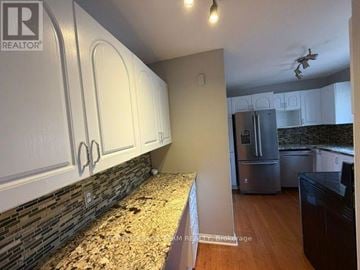 Ottawa apartment for rent - A kitchen with white cabinets and a granite countertop.