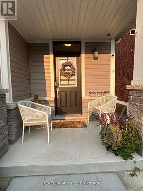 Thorold (Rolling Meadows) townhouse for rent - A front porch with a wreath on the door and two chairs on the steps.