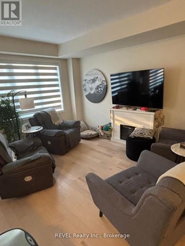 Thorold (Rolling Meadows) townhouse for rent - A living room with a grey couch and a television.