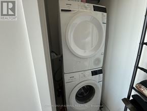 Vaughan (Vaughan Corporate Centre) condo for rent - A stack of white front loading washing machines in a small space.